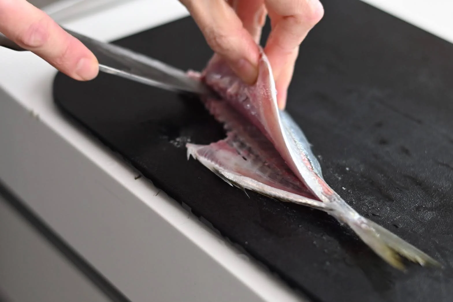 包丁で魚をおろす手元
