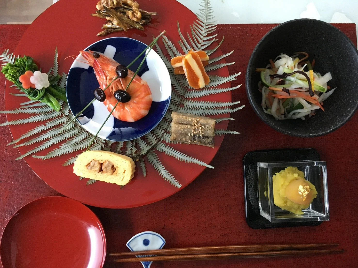 朱の盆に盛り付けたおせちの一皿